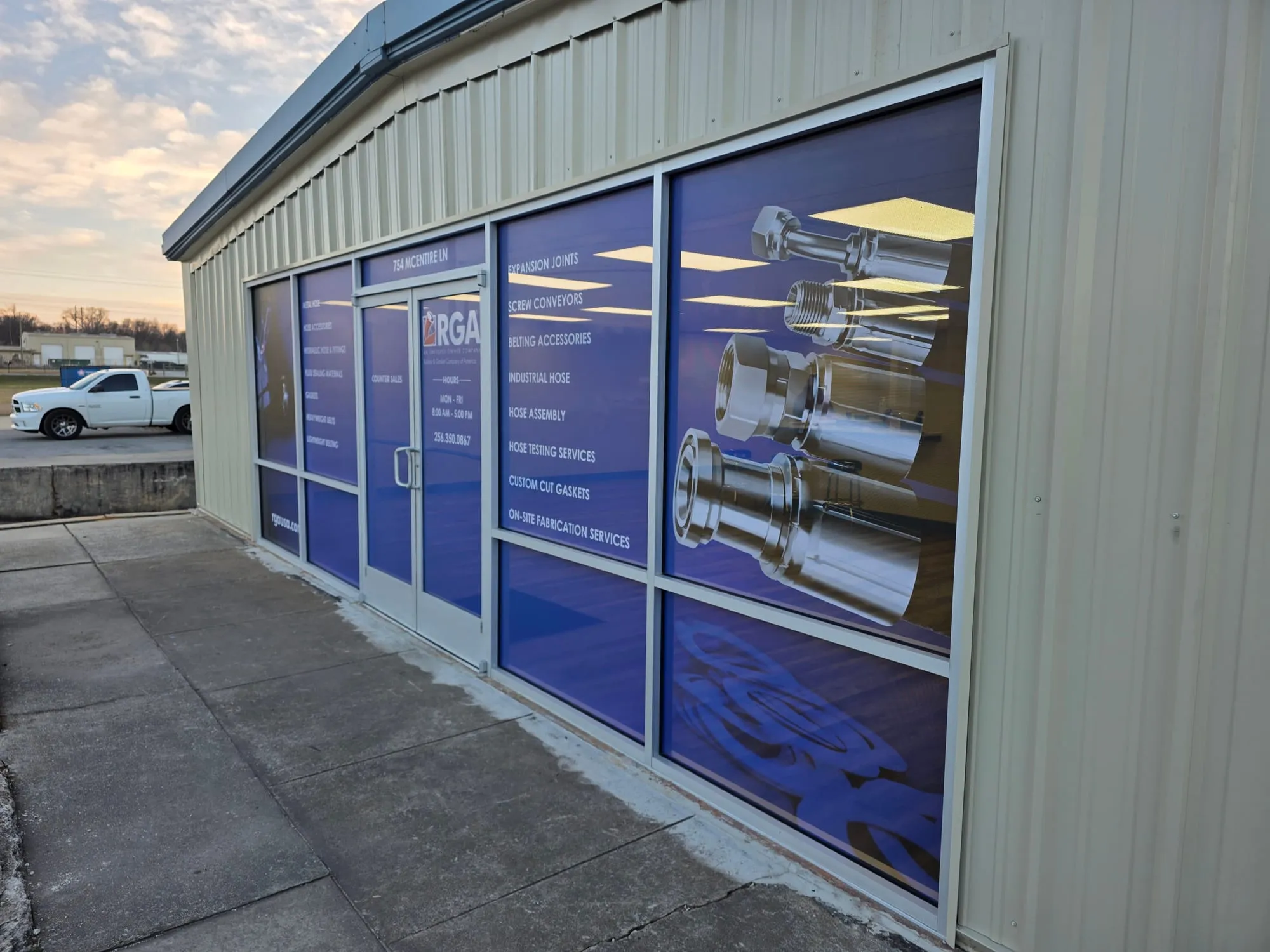View from the other end of the building showing the full run of printed window panels and the glass doors.